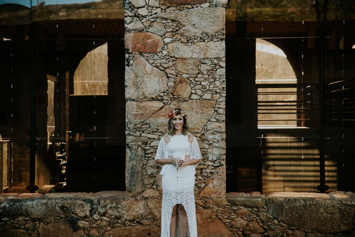 ensaio de pré casamento na serra do caraça no qual a noiva está segurando um terço retro nas mãos