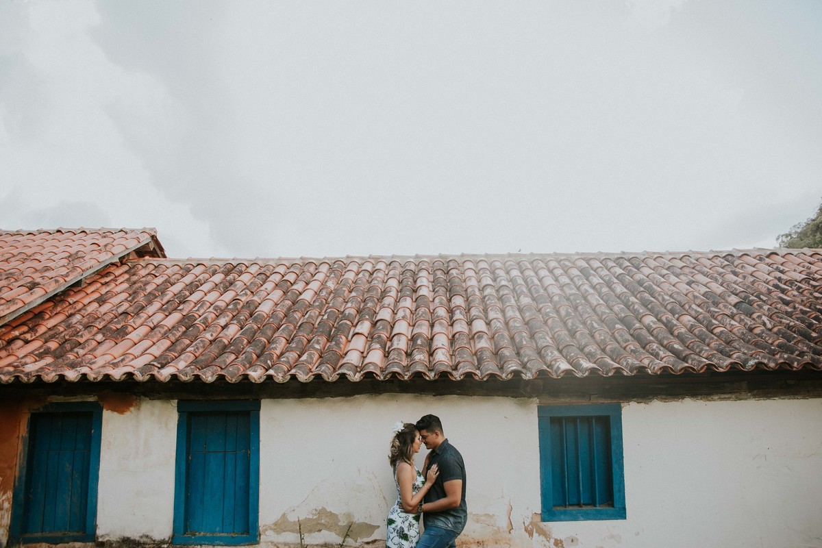 inspiração de pré casamento no qual os noivos estão abraçadinhos na frente de uma construção histórica