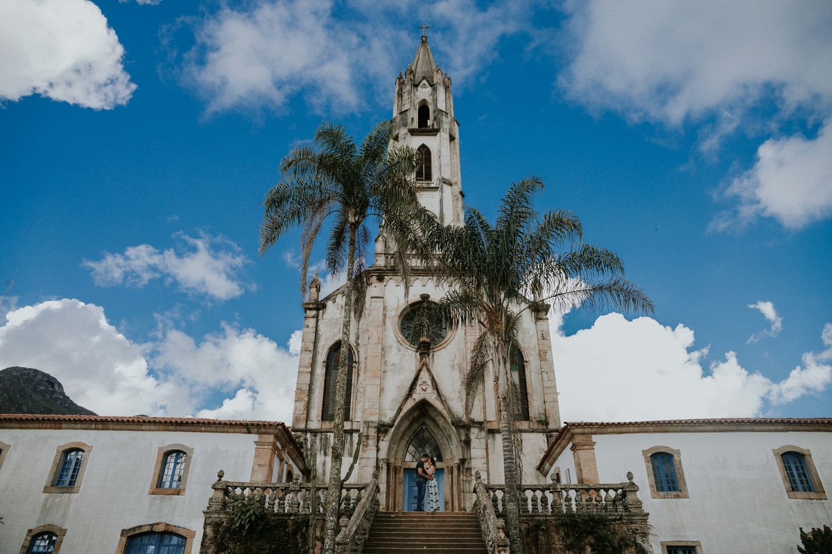 ensaio de pré casamento santuário do caraça no qual os noivos estão na frente da igreja