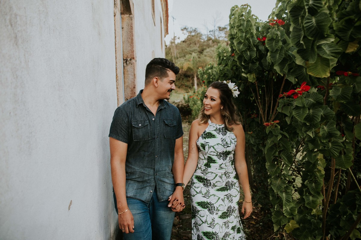 ensaio de pré casamento espontâneo em que os noivos estão caminhando e sorrindo em uma pose criativa de casal 