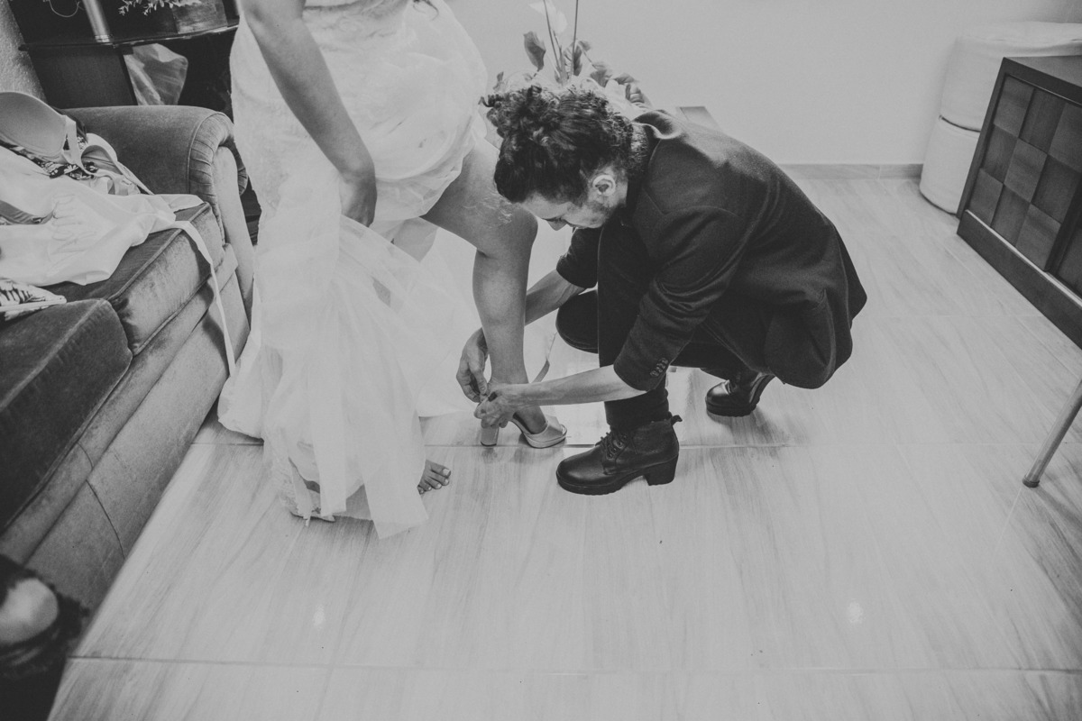 Gui Viegas ajudando a noiva a colocar o sapato para casamento durante o dia da noiva em Belo Horizonte