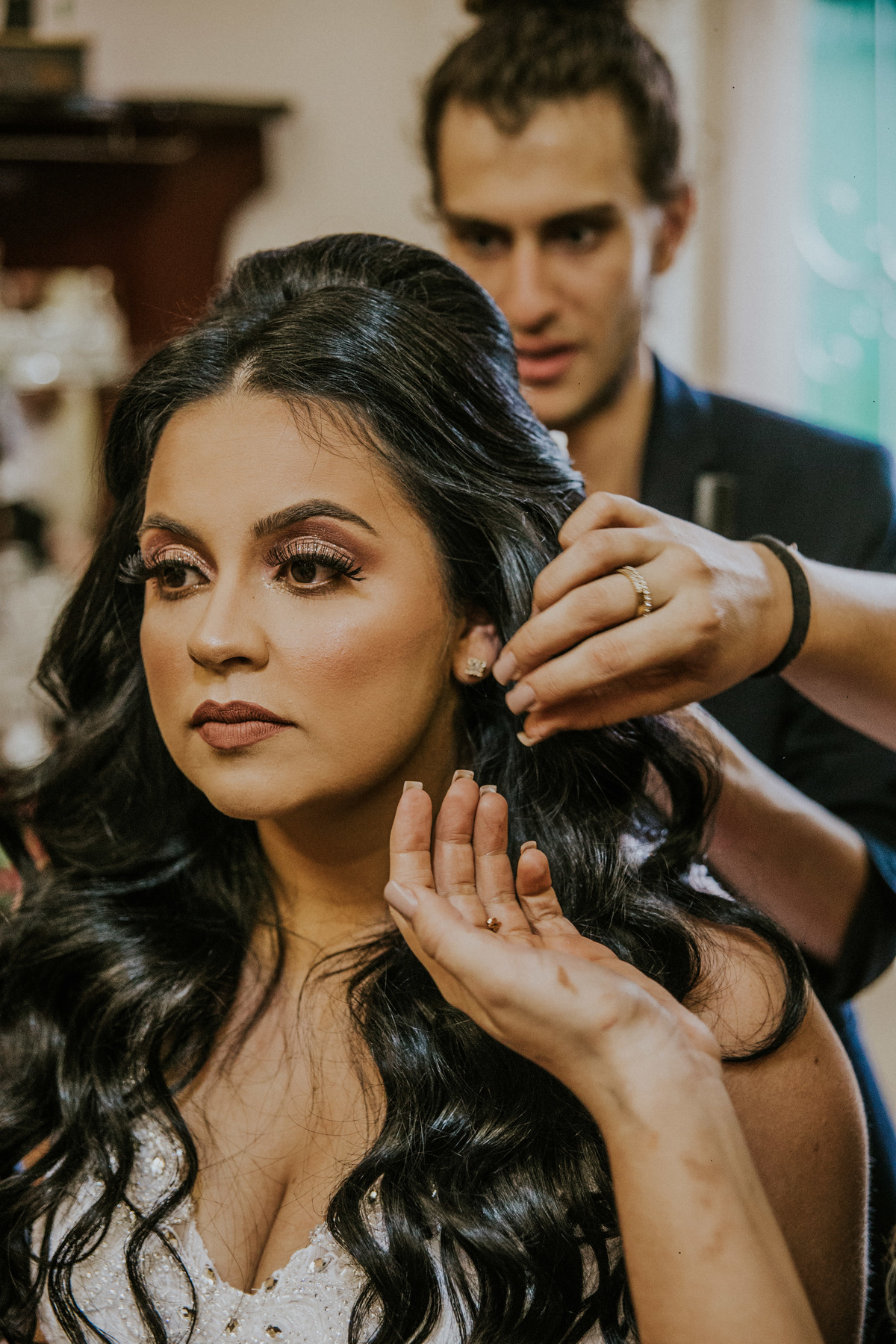 noiva colocando os brincos durante o dia da noiva