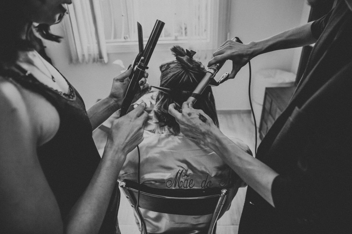 Noiva criando o seu penteado para o casamento em casa durante o making of