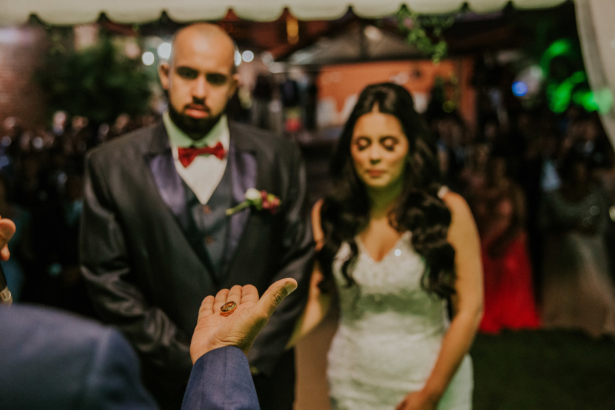 celebrante segurando as alianças nas mãos e abençoando