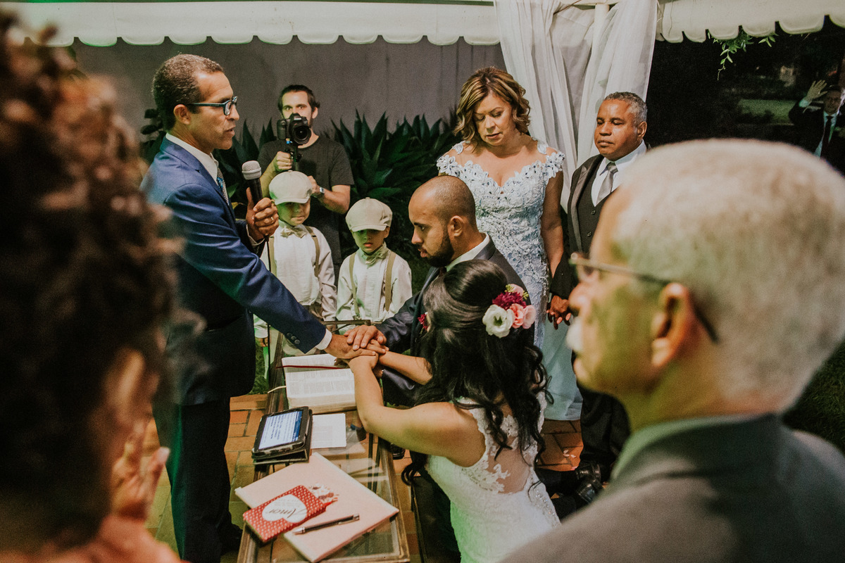 noivos sendo abençoados pelo pastor e pelos pais durante a cerimônia de casamento