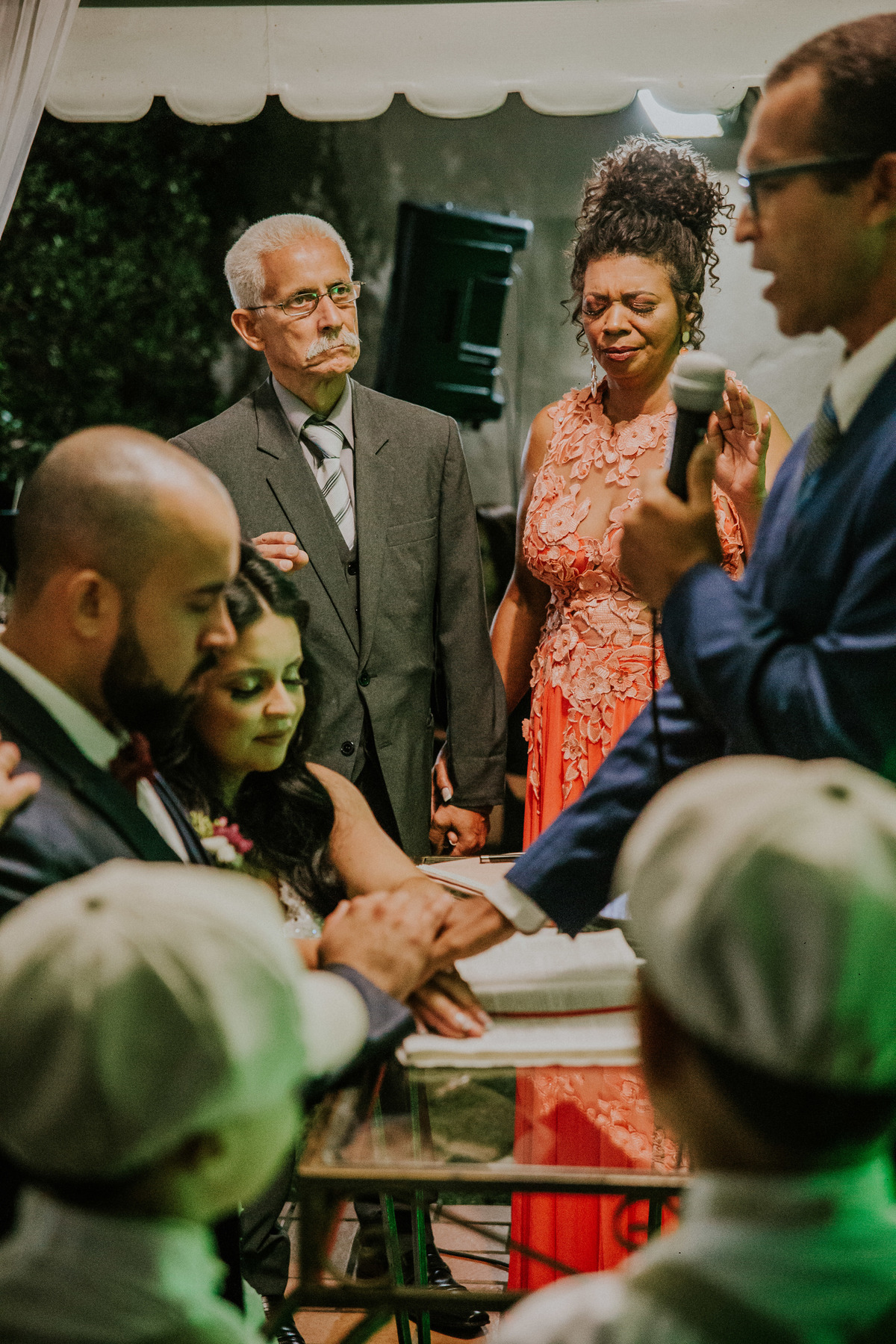 noivos sendo abençoados pelo pastor e pelos pais durante a cerimônia de casamento