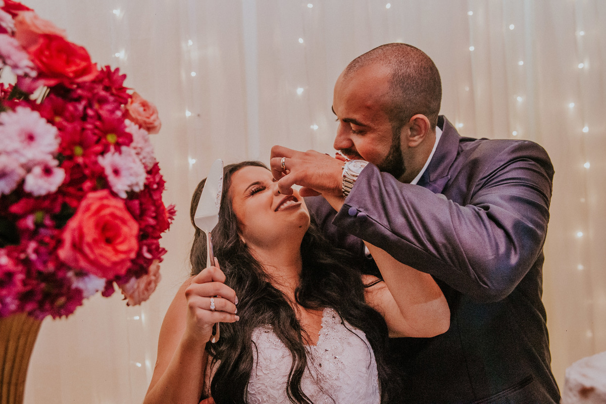 fotografia divertida do corte do bolo de casamento