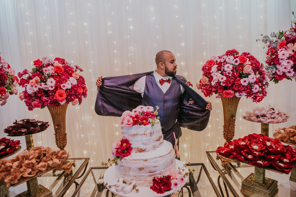 noivo sensualizando antes de cortar o bolo de casamento
