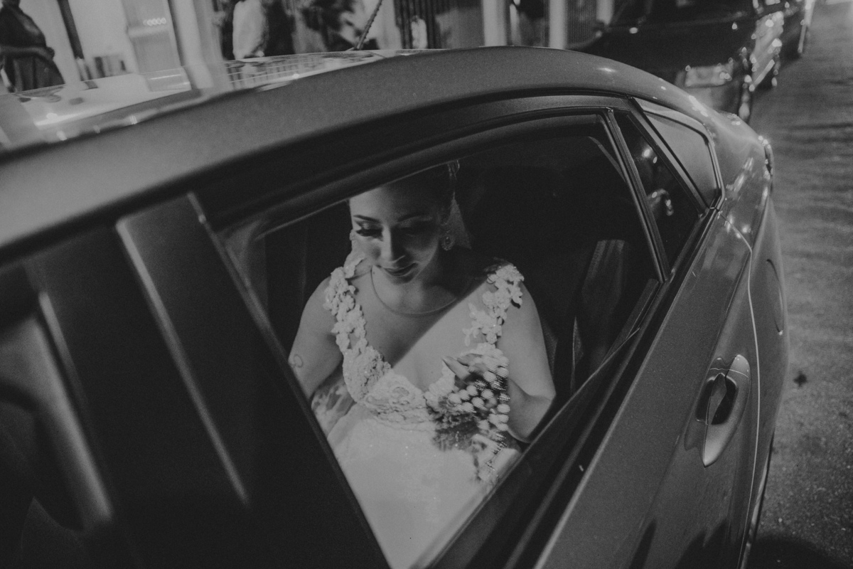 fotografia da noiva dentro do carro segurando um terço de perolas 