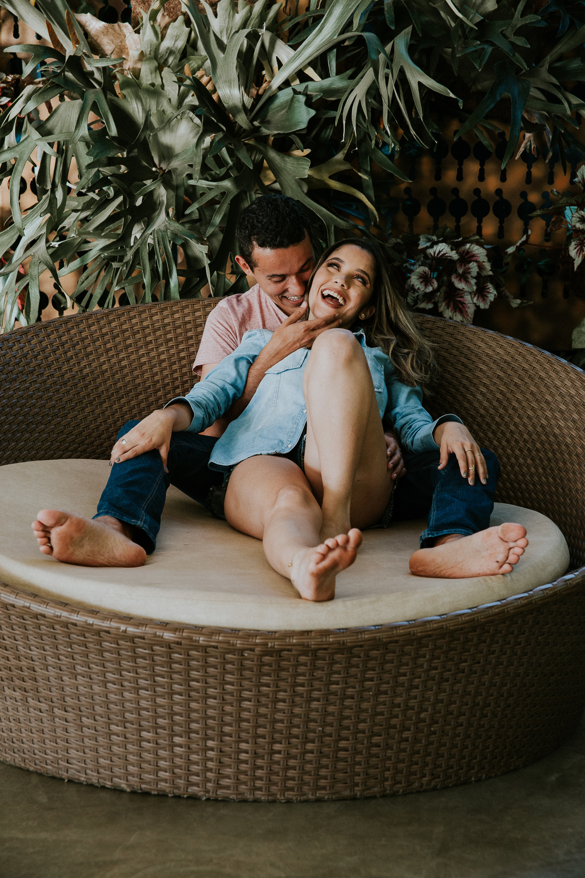 Fotografia espontânea de casal no qual os dois estão sentados em um sofá e sorrindo