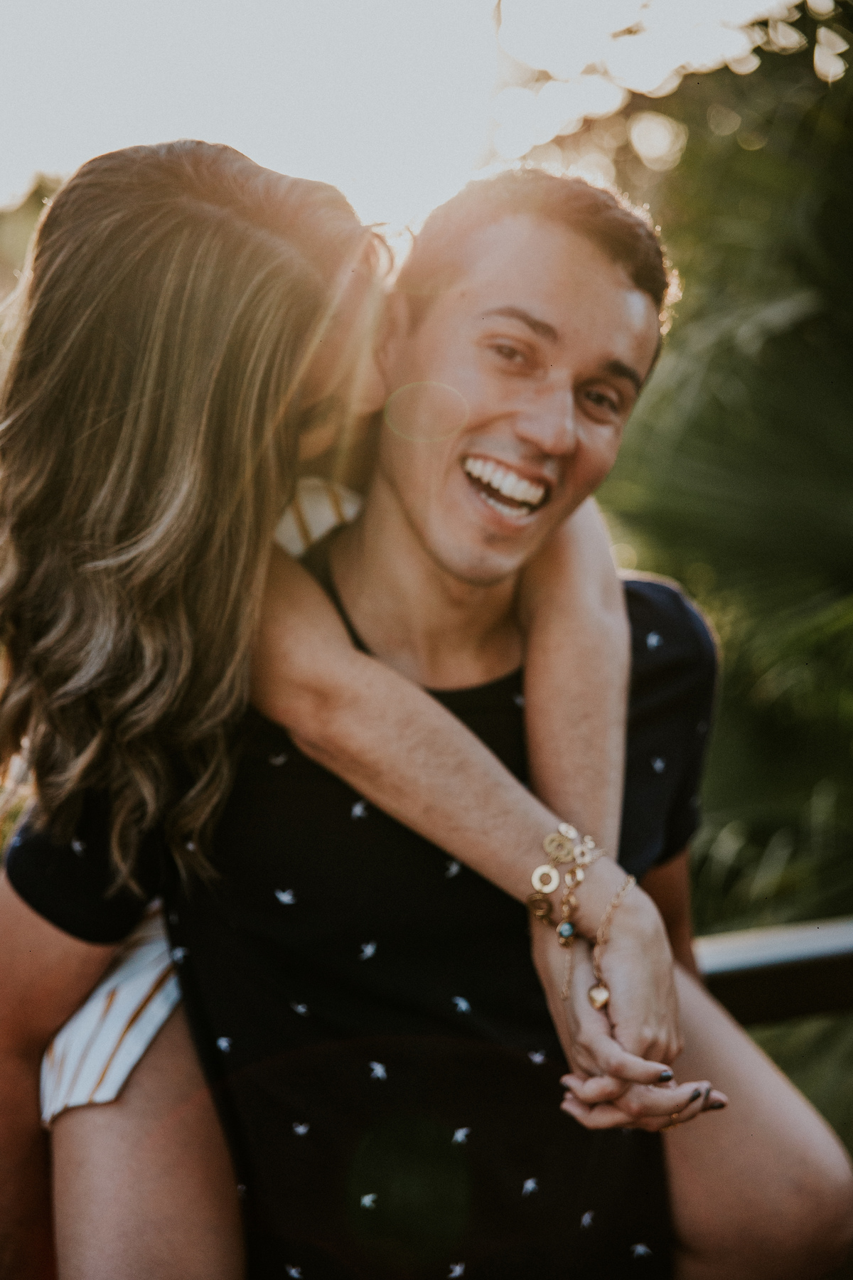 Casal se abraçando e sorrindo um para o outro durante um ensaio de casal em Betim