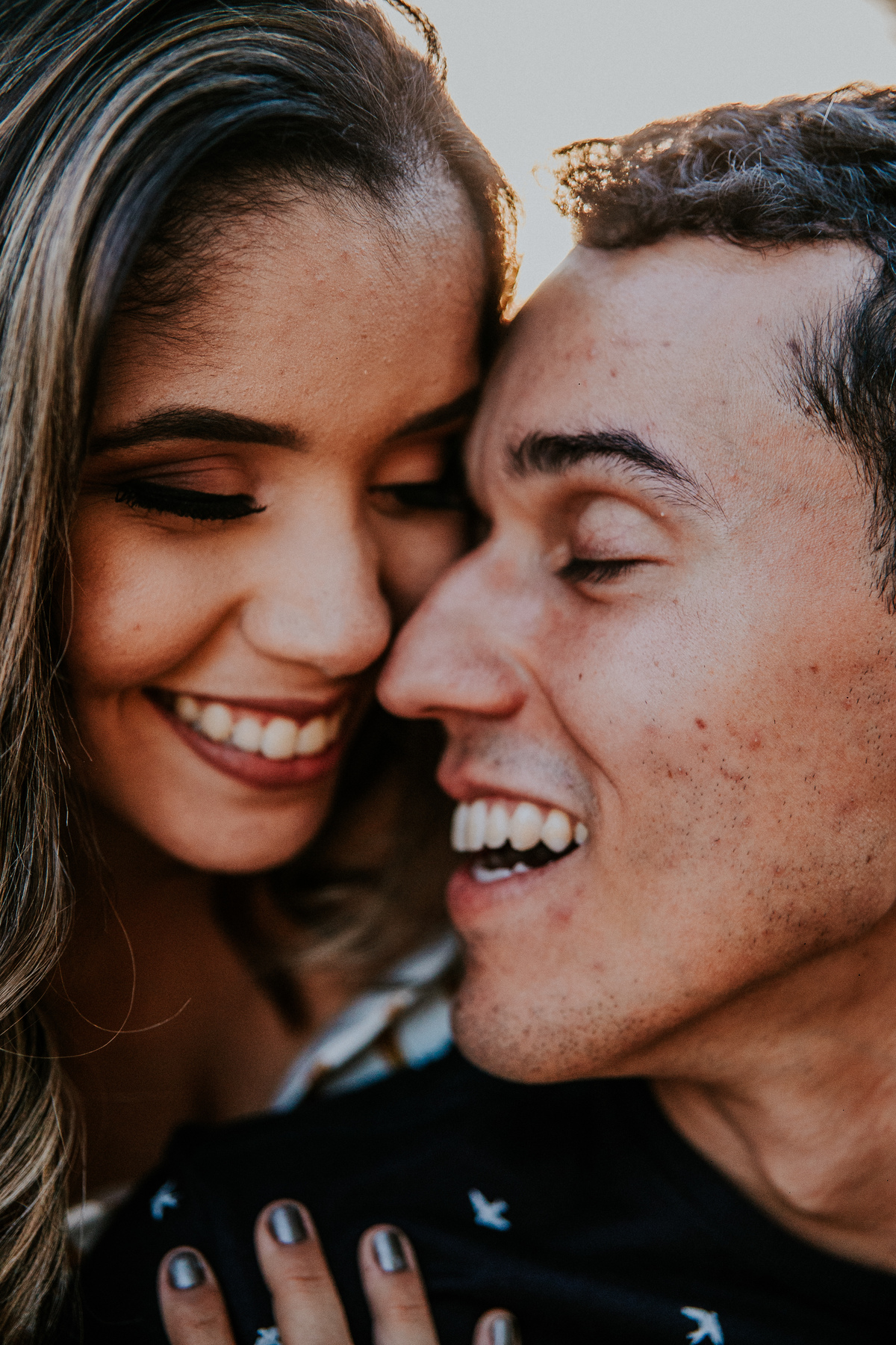 Casal sorrindo em uma fotografia espontânea de casal no por do sol