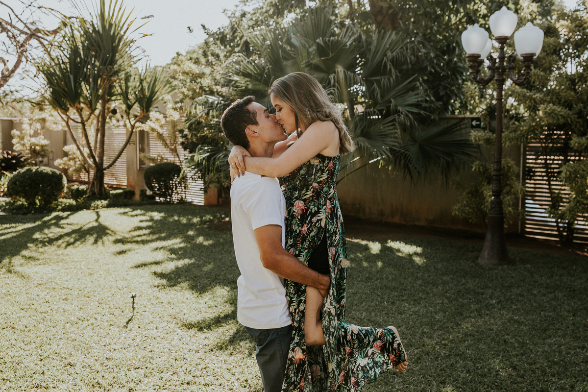 fotografia criativa de casal no qual o namorado esta segurando sua namorada nos braços e se beijando