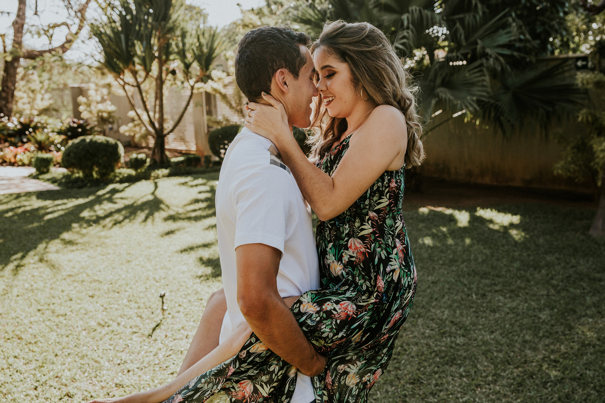 fotografia criativa de casal no qual o namorado está carregando sua namorada no colo em um espaço para casamentos e ensaios em betim