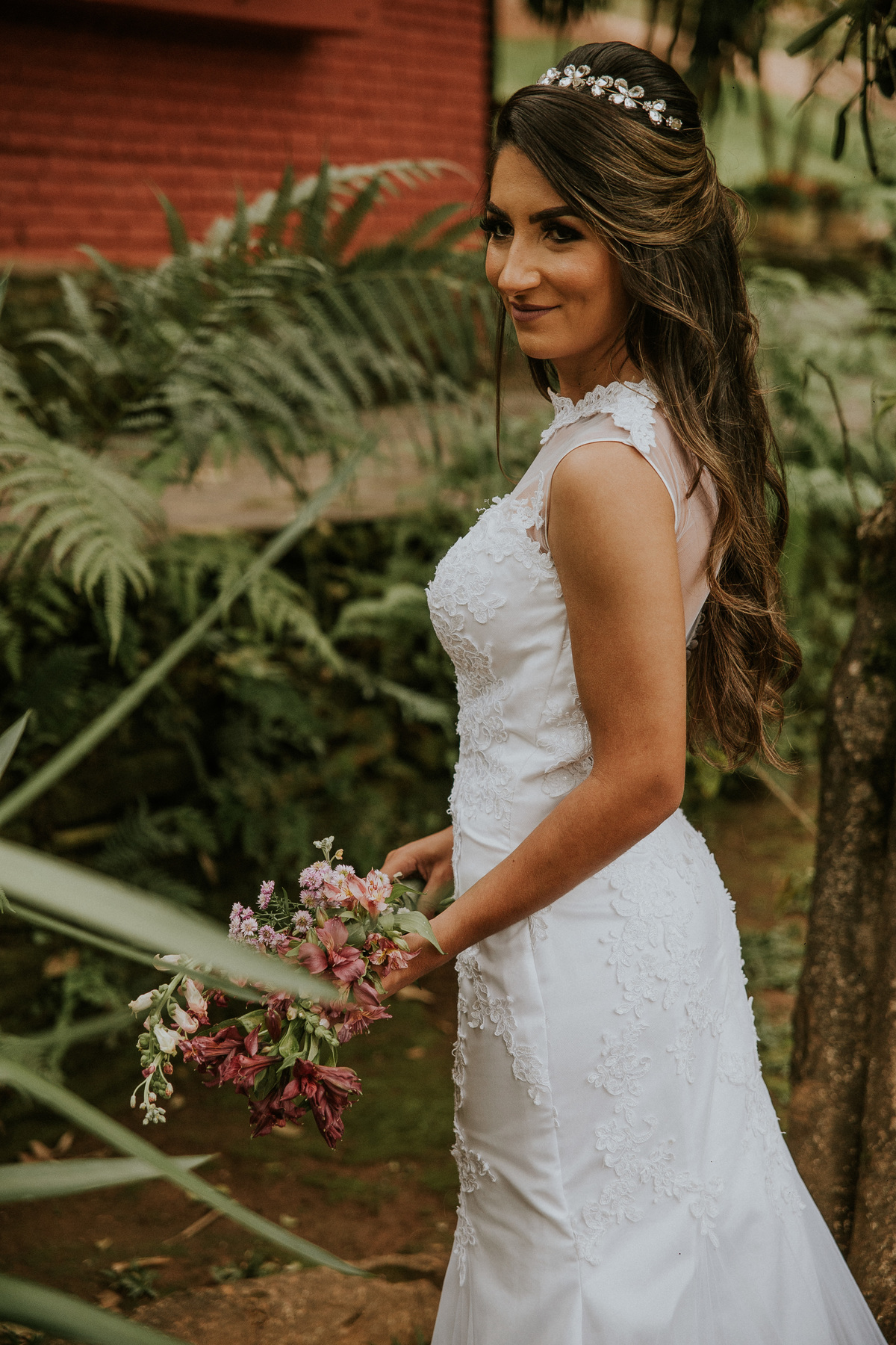 fotografia de oós casamento fazenda arraial velho em sabara no qual a noiva está de costas e segurando o seu buque de noiva