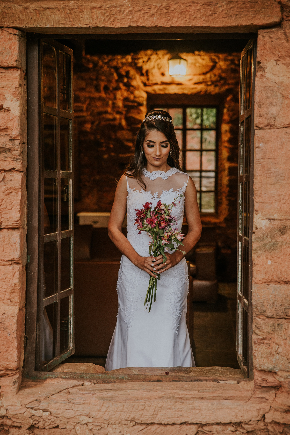 retrato de pós casamento no qual a noiva está na janela e olhando para o seu buque