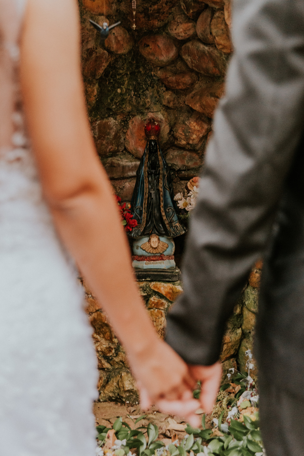 fotografia de casamento católico rustico no qual a santa nossa senhora aparecida está na foto abençoando o casal
