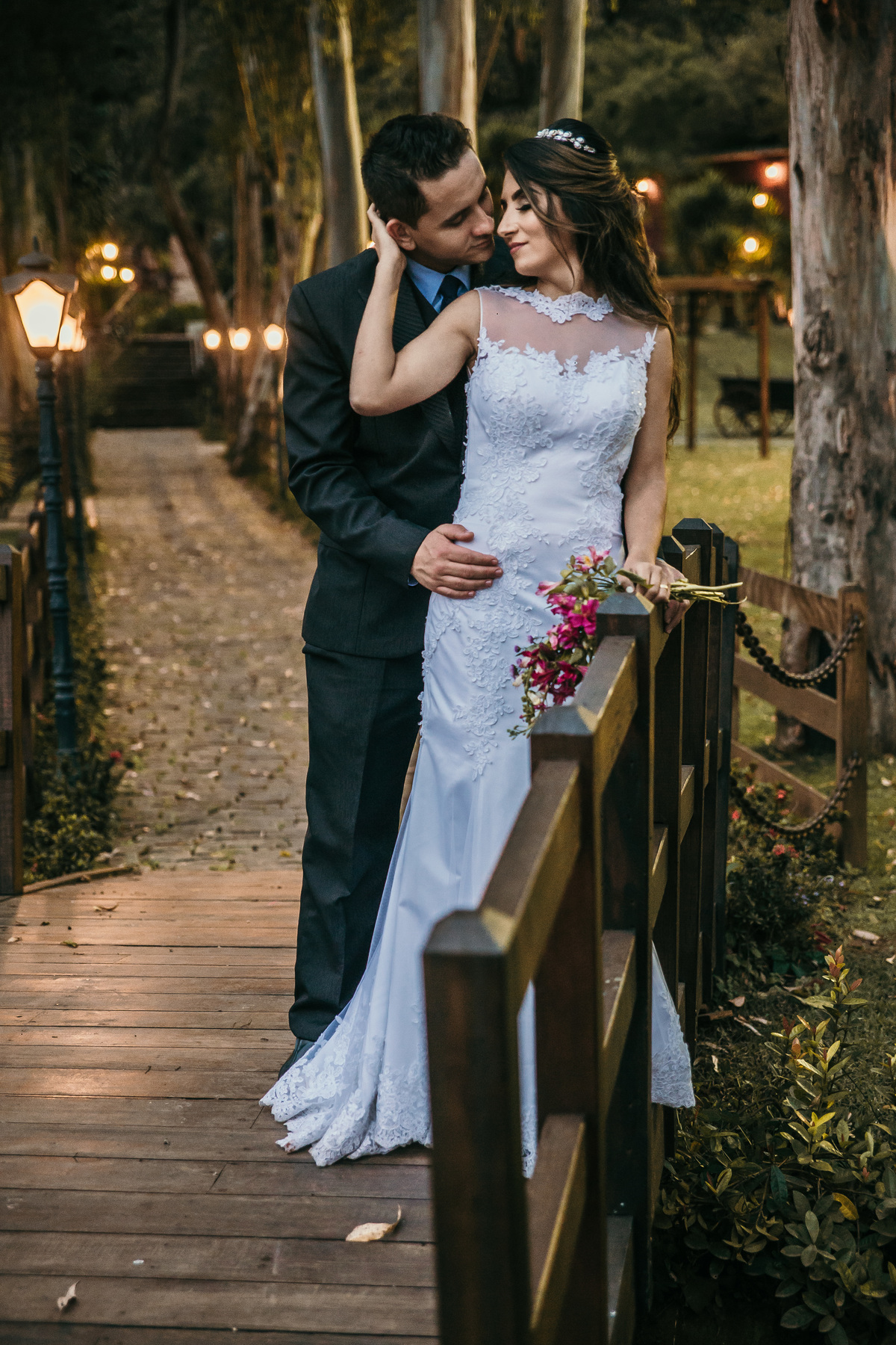 fotografia de pós casamento rustico no qual o noivo está abraçado a noiva em cima de uma ponte