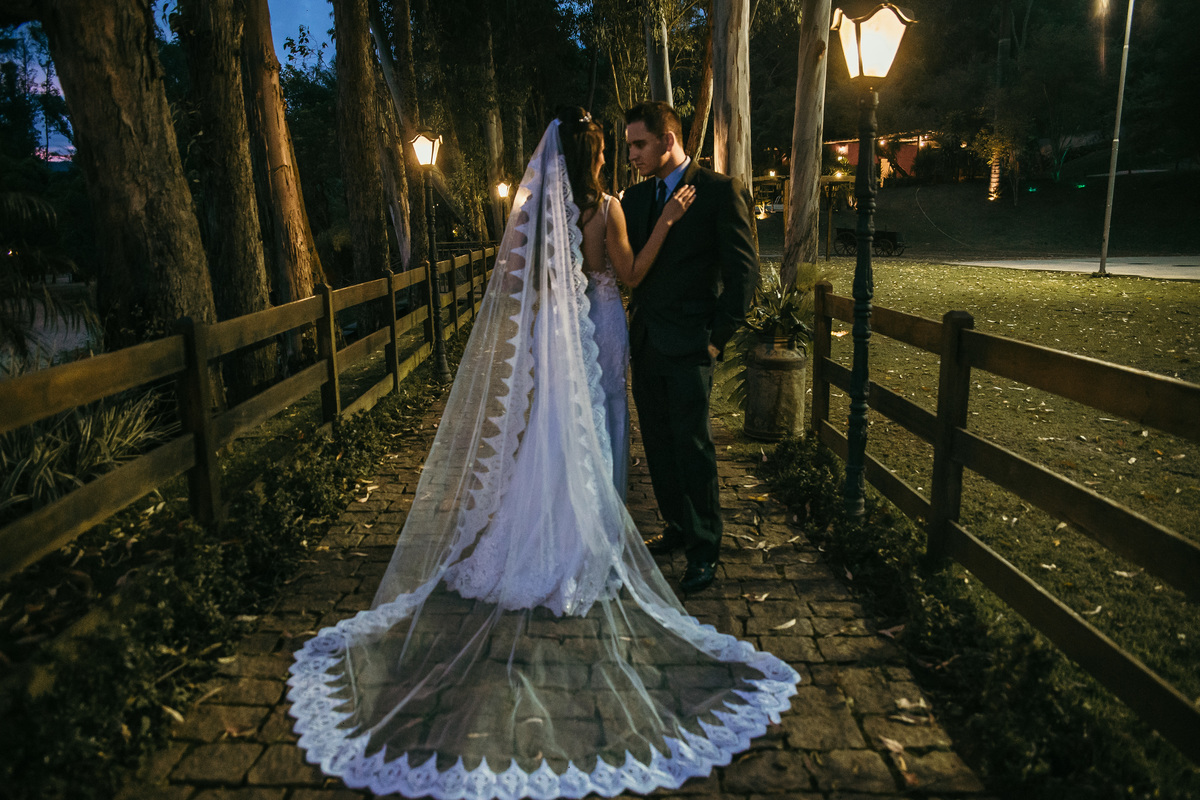 Fotografia de pós casamento rustico no qual a noiva está usando um vestido com um véu longo para o dia