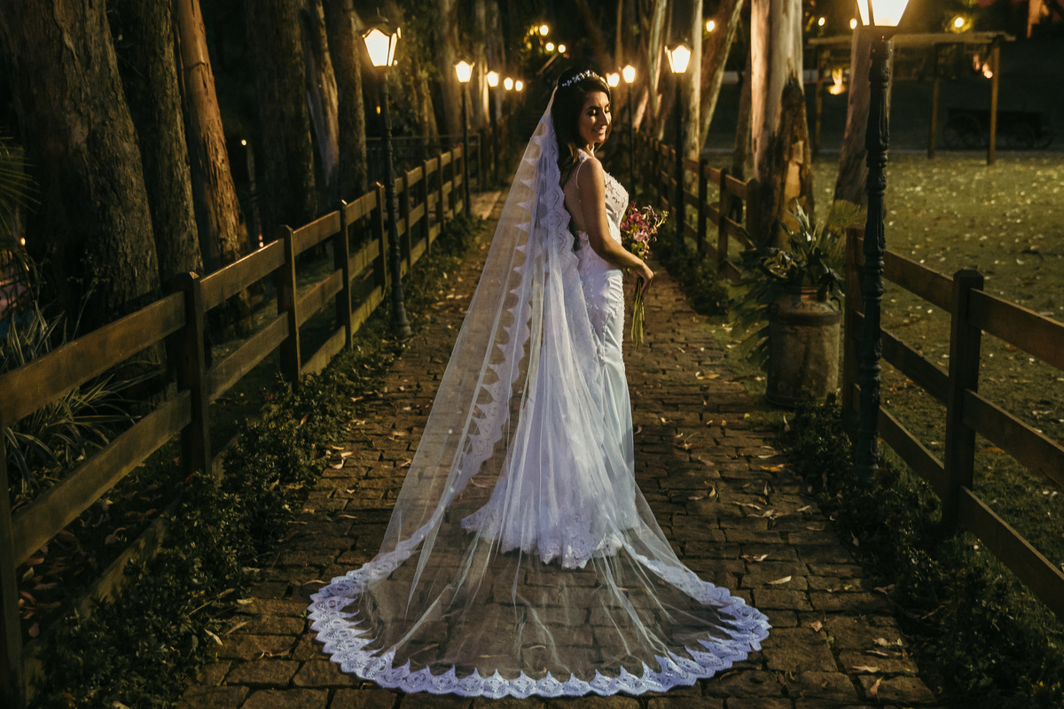 Fotografia de pós casamento rustico no qual a noiva está usando um vestido com um véu longo para o dia