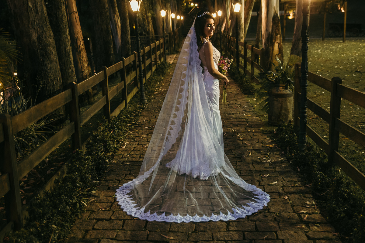 Fotografia de pós casamento rustico no qual a noiva está usando um vestido com um véu longo para o dia