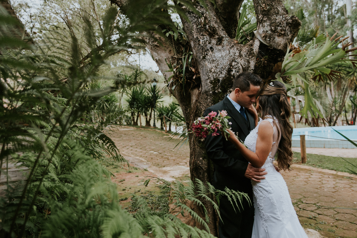 Fotografia de pós casamento na fazenda arraial velho em sabara no qual os noivos estão cercados pela natureza e se olhando