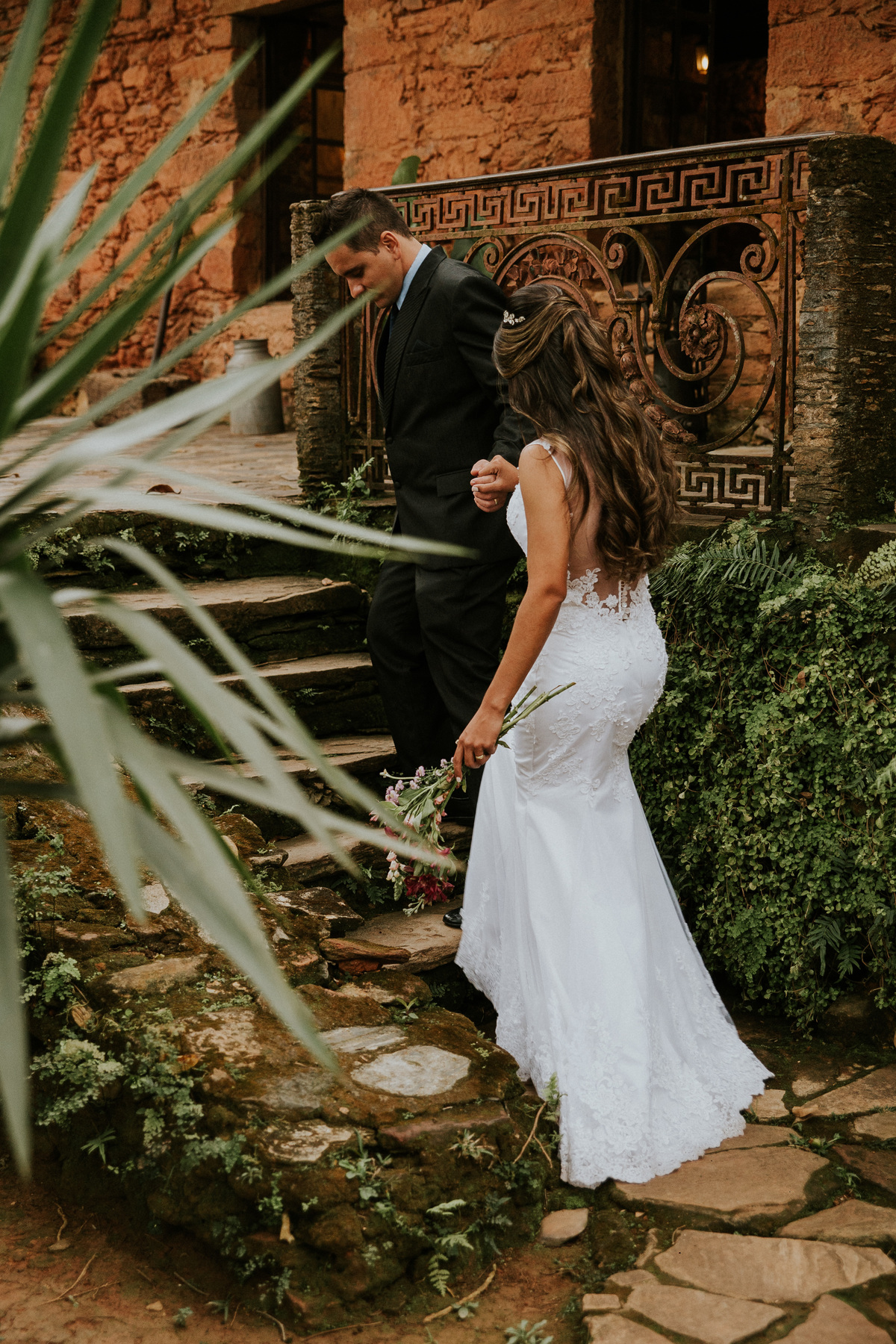 Fotografia criativa de pós casamento rustico na fazenda arraial velho em sabara no qual os noivos estão de mãos dadas e caminhando juntos