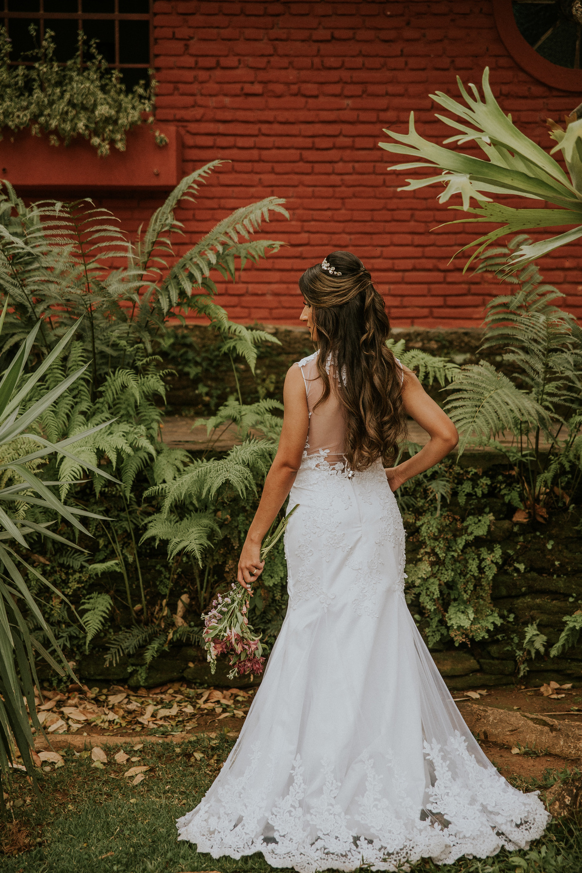 fotografia de oós casamento fazenda arraial velho em sabara no qual a noiva está segurando o buque de noiva e mostrando seu vestido de noiva estilosereia