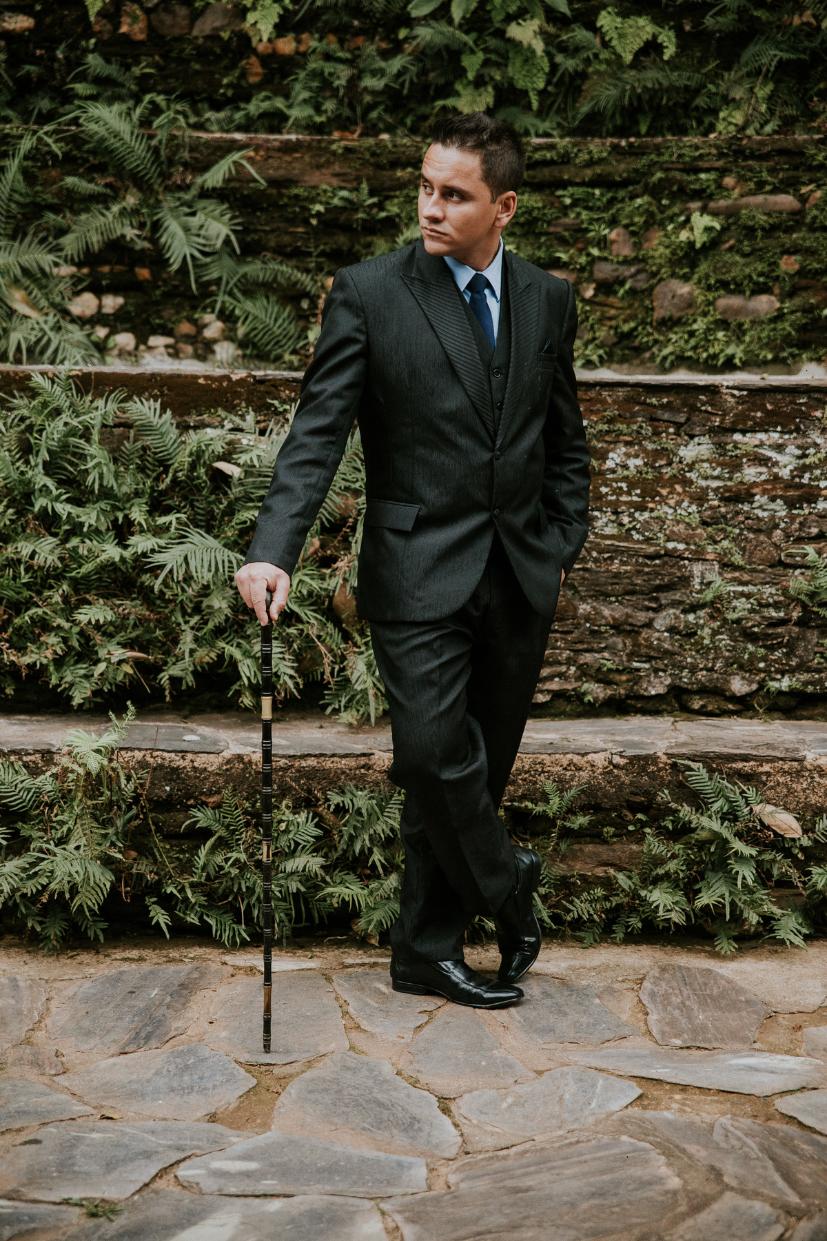 retrato criativo do noivo na fazenda arraial velho em sabara no qual ele está usando uma bengala como acessório criativo para noivo