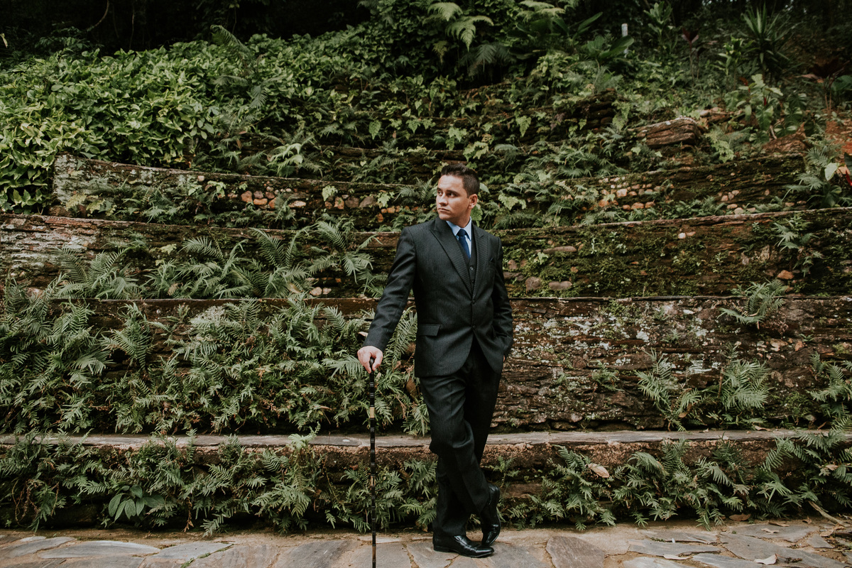 retrato criativo do noivo na fazenda arraial velho em sabara no qual ele está usando uma bengala como acessório criativo para noivo