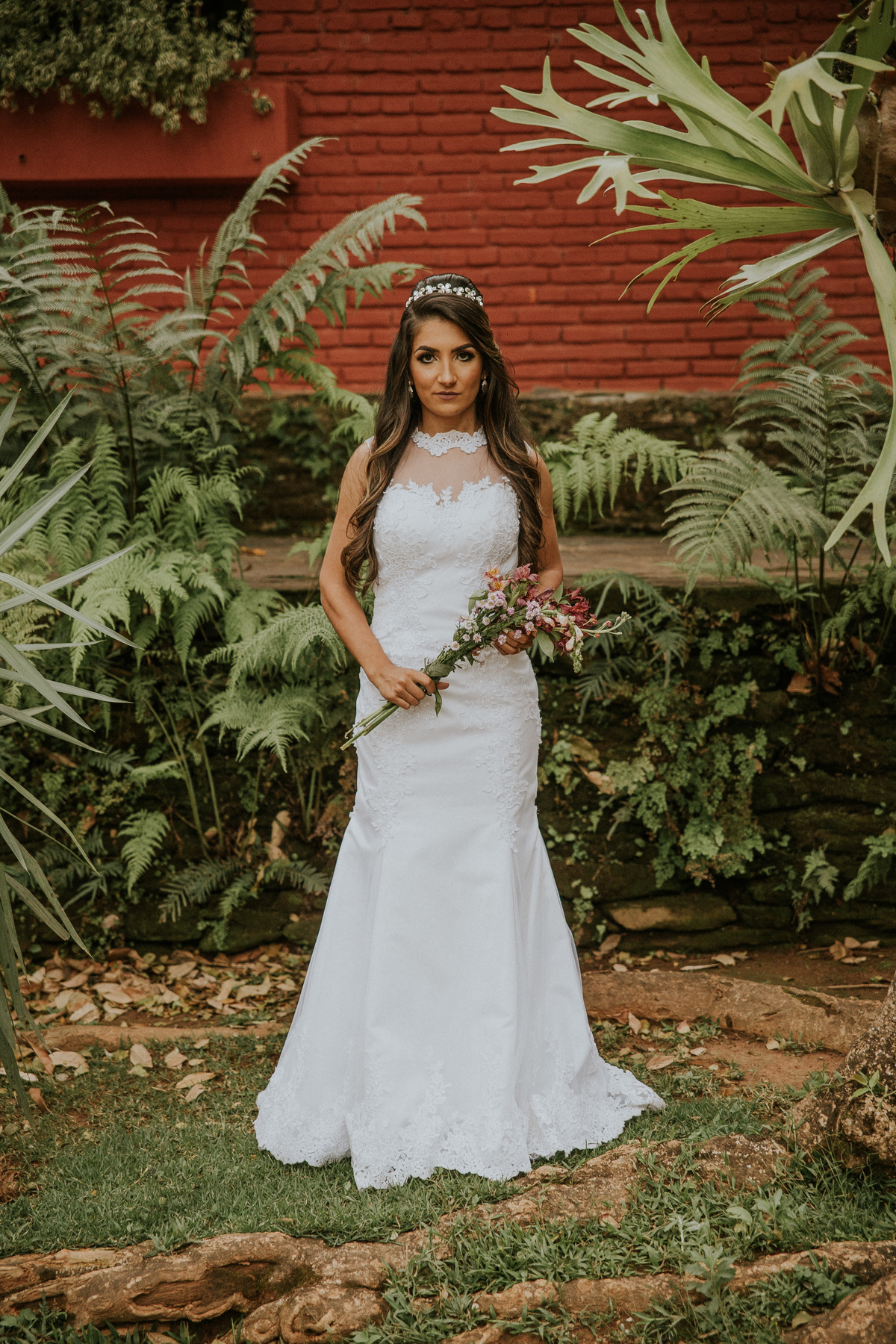 fotografia de oós casamento fazenda arraial velho em sabara no qual a noiva está segurando o buque de noiva e mostrando seu vestido de noiva estilo sereia
