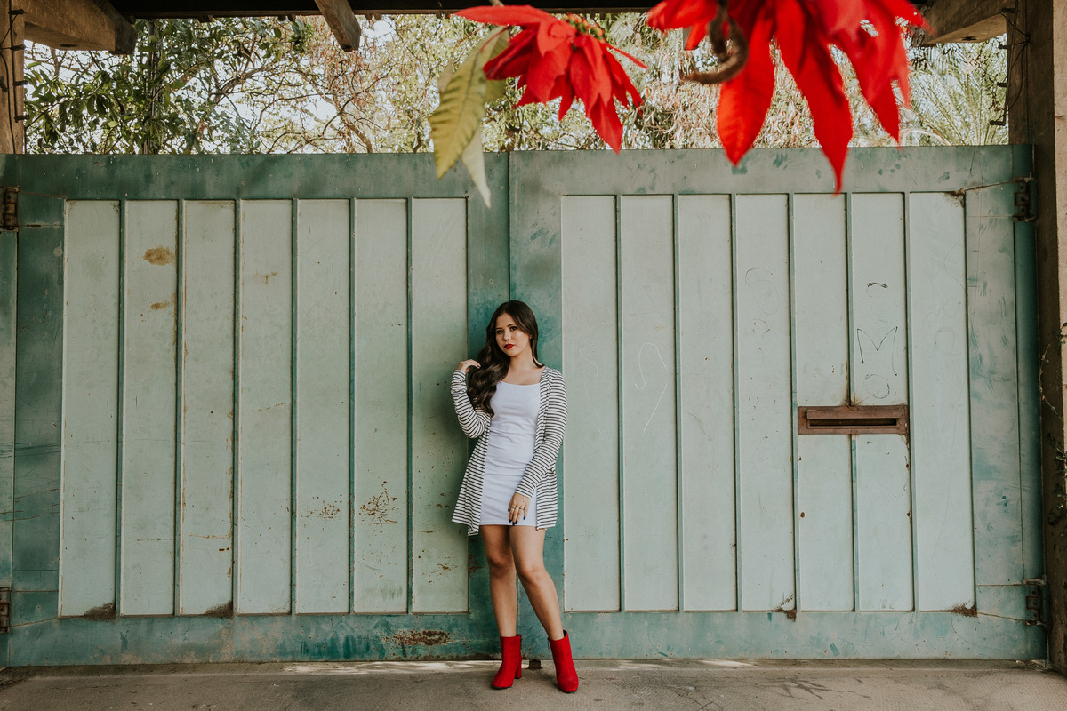 Ensaio de 15 anos em betim no qual a modelo está na frente de um portão no centro de Betim