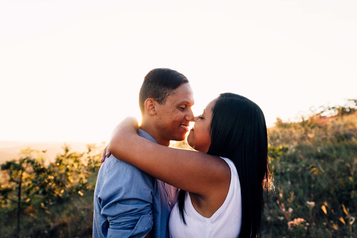 fotos no por do sol de recem casados, eles estão sorrindo e abraçados olhando um para o outro com um olhar apaixonado