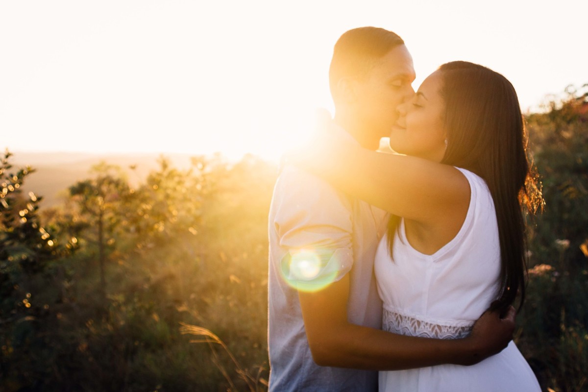 fotos no por do sol de recem casados, eles estão sorrindo e abraçados olhando um para o outro com um olhar apaixonado