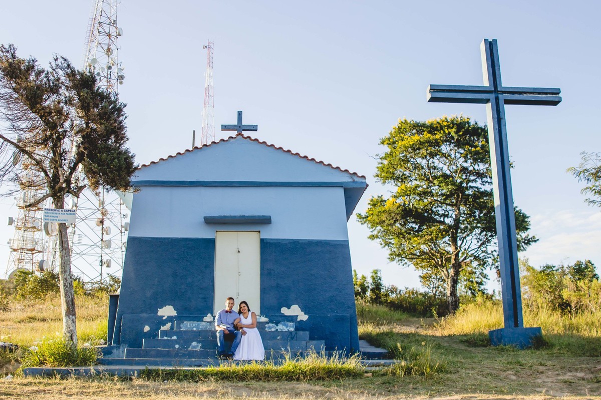fotos no por do sol de recem casados, na frente de uma igreja azul