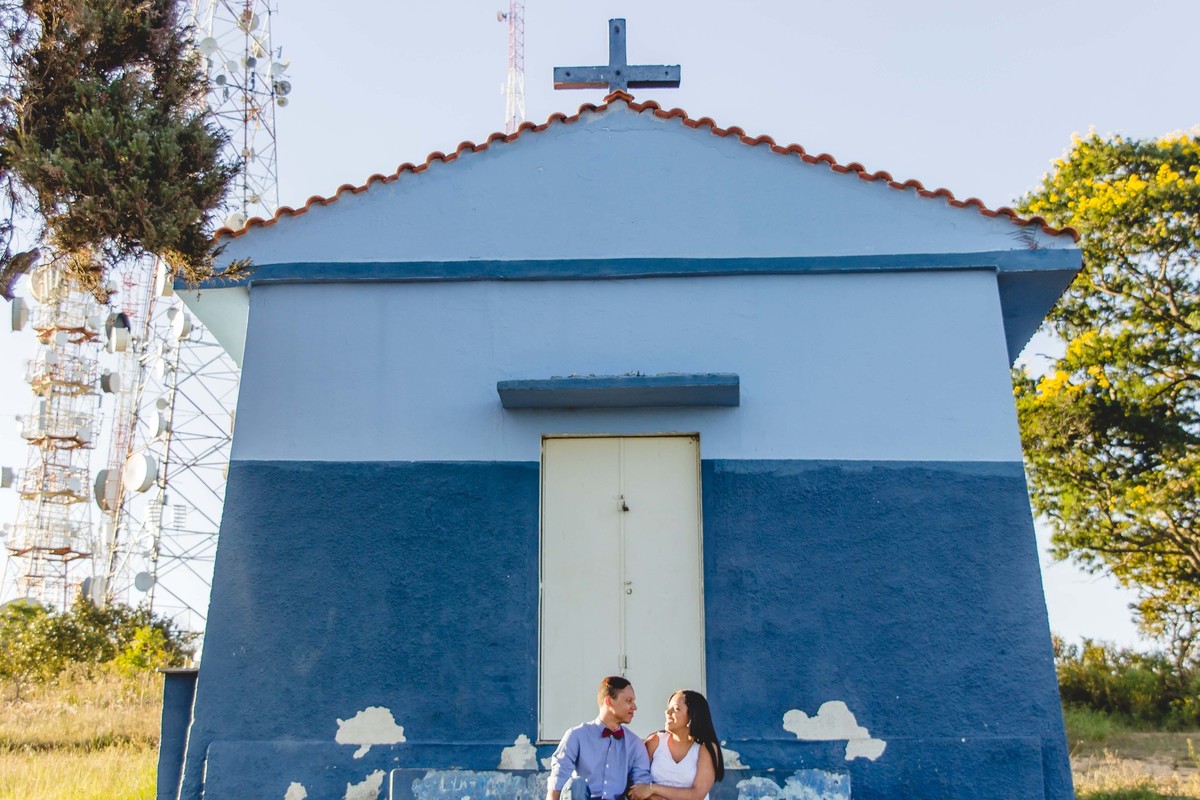 fotos no por do sol de recem casados, na frente de uma igreja azul