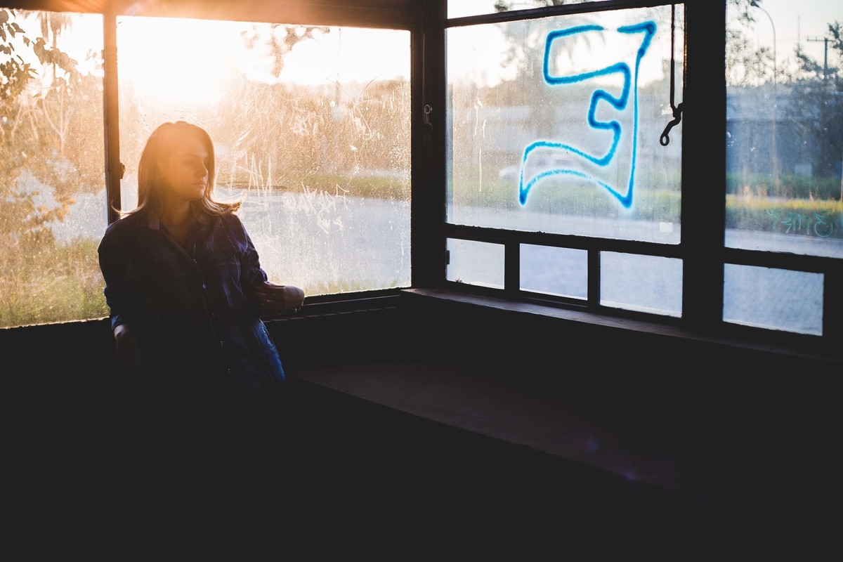 Ensaio fotografico no por do sol, mulher usando roupas masculinas e aboatoando a camisa, fotos feitas em Juatuba em posto abandonado