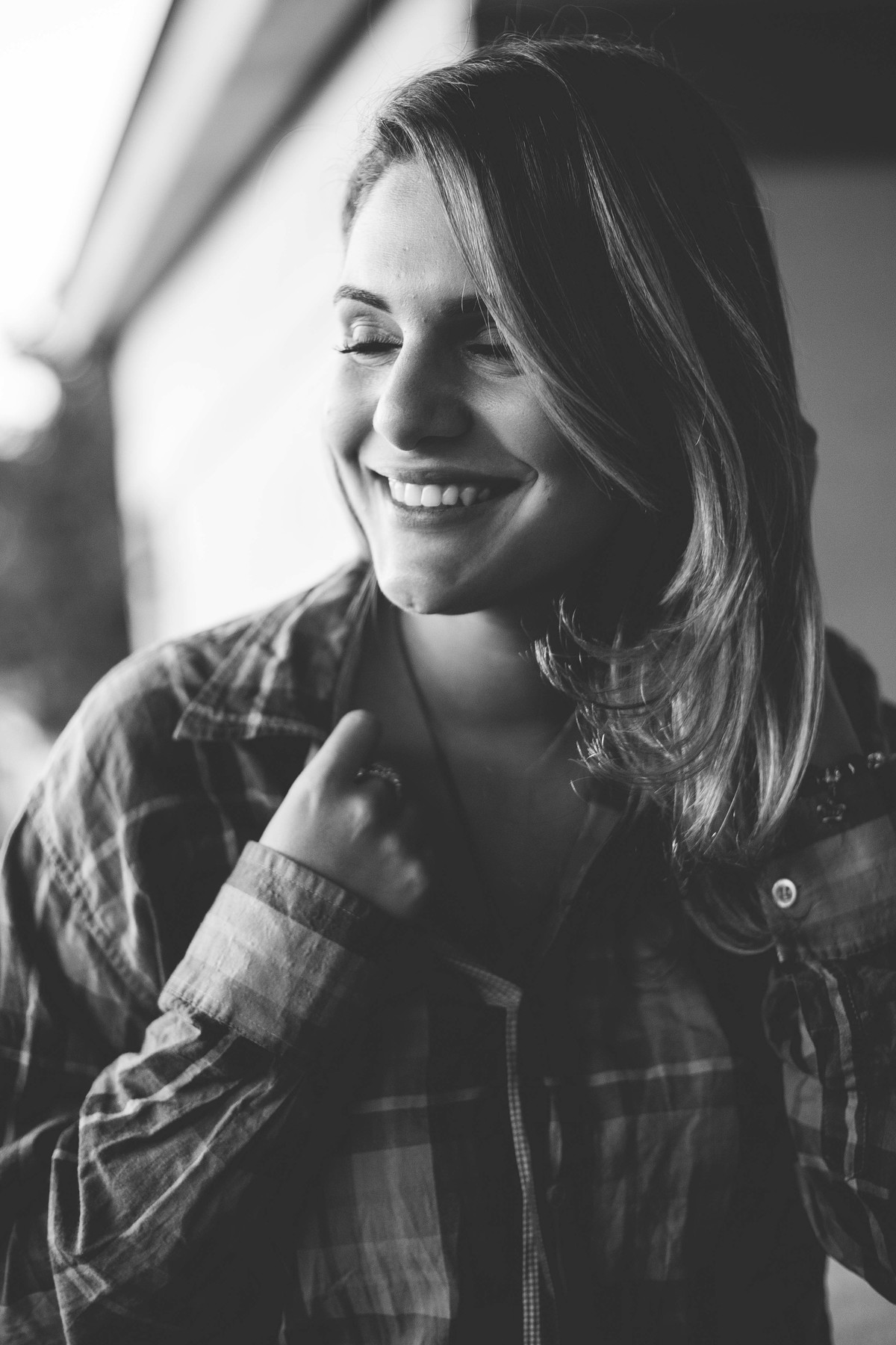 Ensaio fotografico no por do sol, mulher usando roupas masculinas e aboatoando a camisa, fotos feitas em Juatuba em posto abandonado, foto sorrindo em preto e branco e segurando a blusa