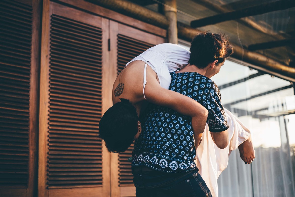 Ensaio divertido de casal, namorado carregando a namorada no colo