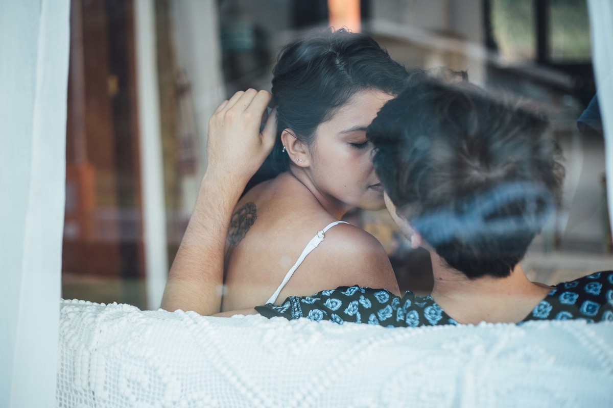 Ensaio de casal em casa, sentados no sofa com um cachorrinho