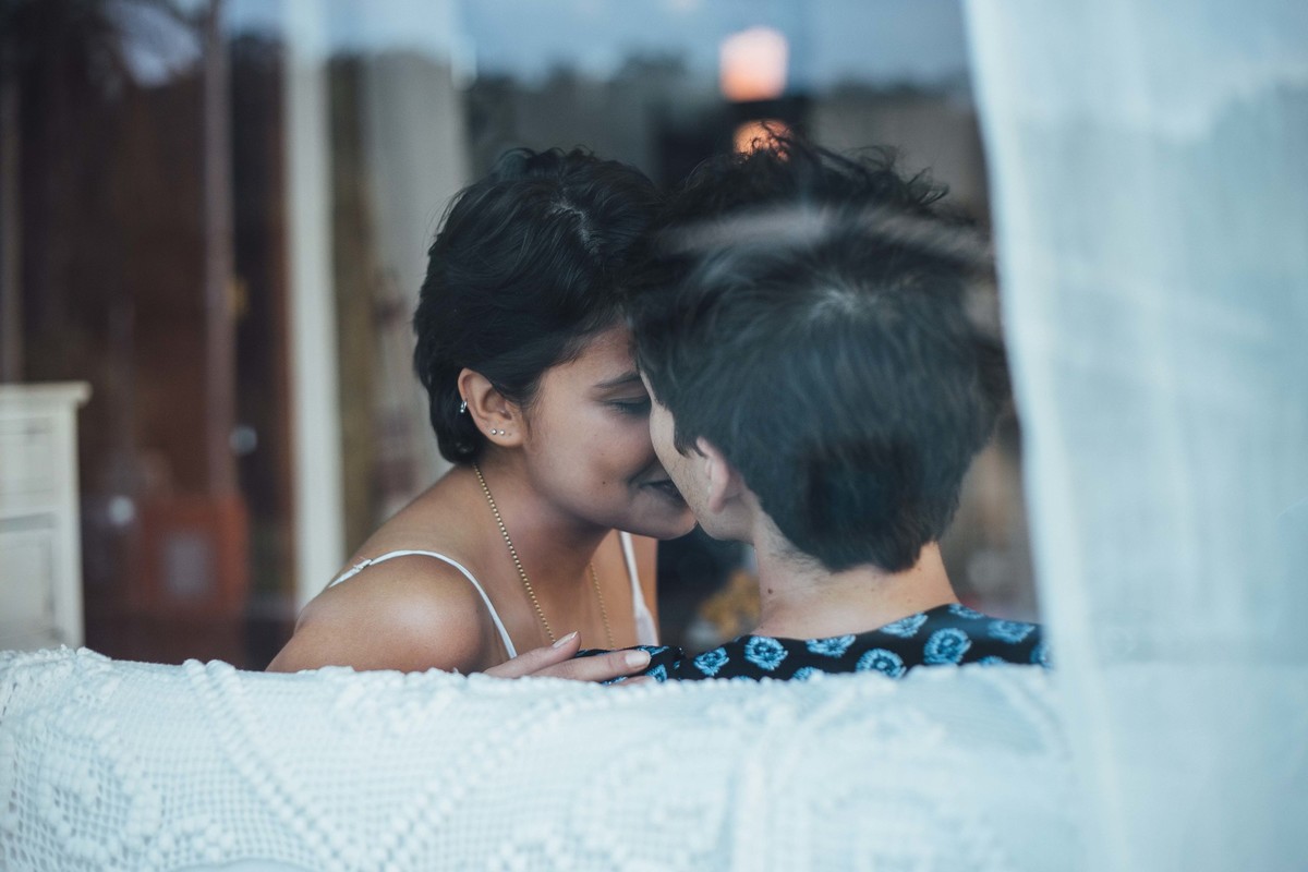 Ensaio de casal em casa, sentados no sofa com um cachorrinho