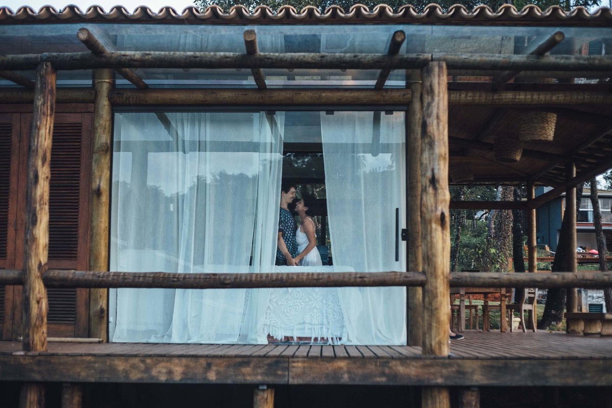 Ensaio de casal em casa, sentados no sofa com um cachorrinho