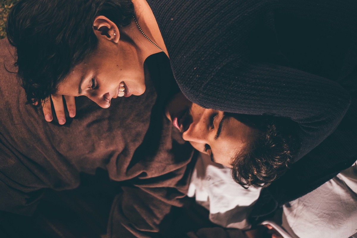 Foto de casal a noite com varal de luz, casal se olhando