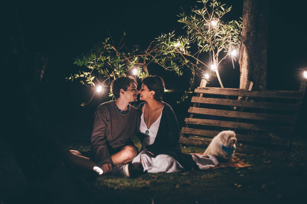 Foto de casal a noite com varal de luz, casal se olhando