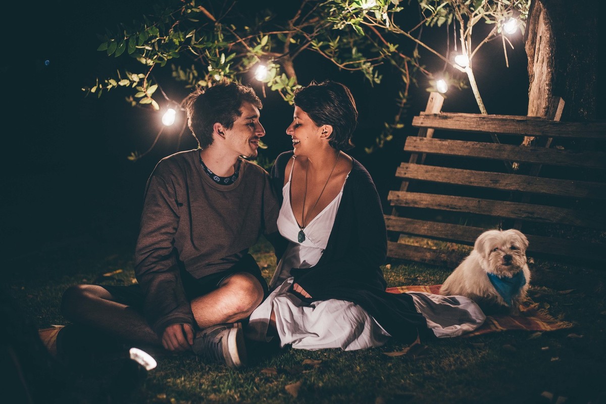 Foto de casal a noite com varal de luz, casal se olhando