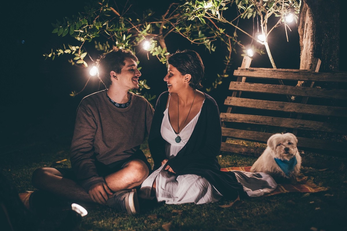 Foto de casal a noite com varal de luz, casal se olhando