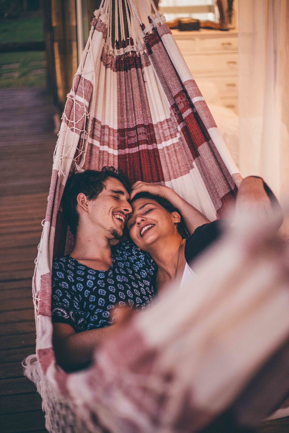foto de casal apaixonados deitados na rede e olhando um para o outro