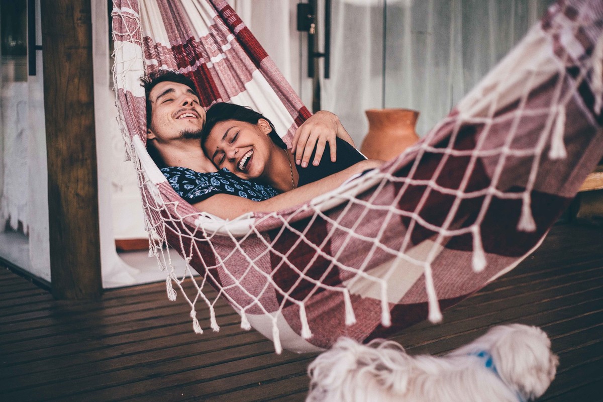 foto de casal apaixonados deitados na rede e olhando um para o outro