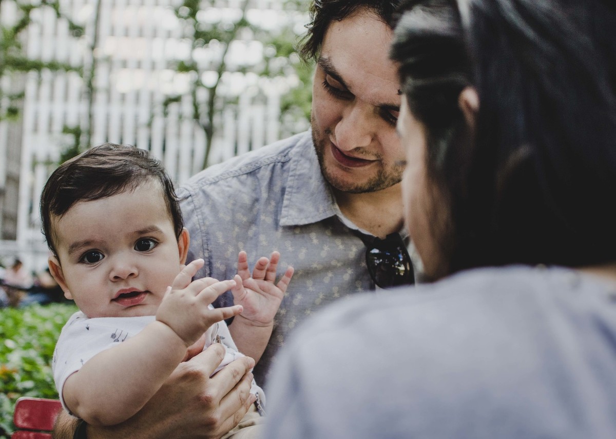 Ensaio fotográfico de família em Nova York, pai segurando filho no colo, criança olha para a câmera