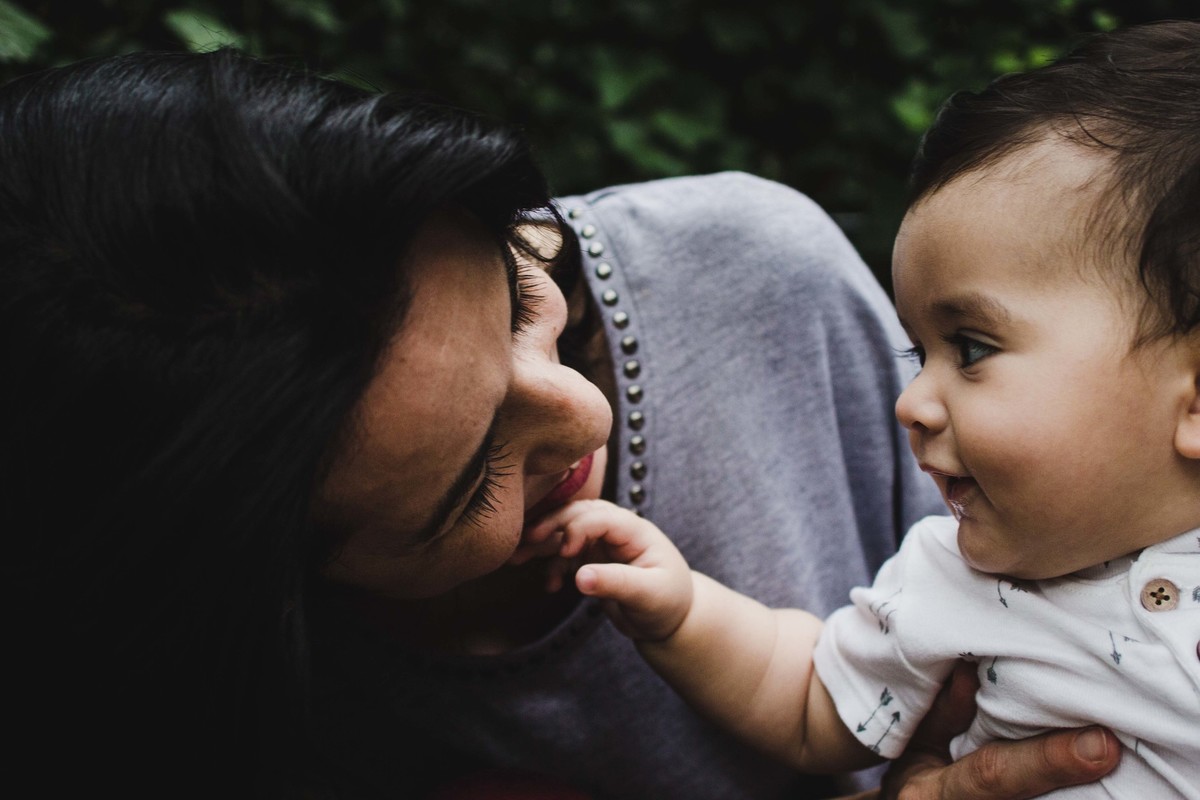 Ensaio fotográfico de família em Nova York, mãe olha para filho que olha para mãe e toca em seu rosto